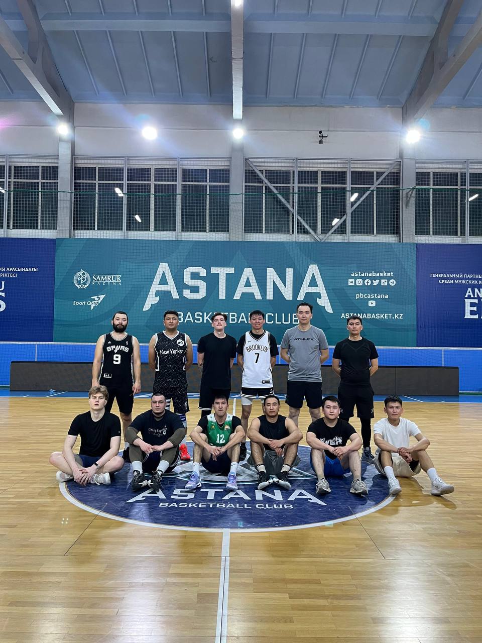 Команда в чёрной форме на центральном круге Astana Basketball Club